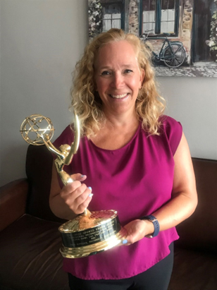 Fran Rotella holding her emmy award.