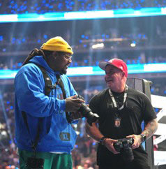 Ed Mulholland talking with another photographer at a stadium